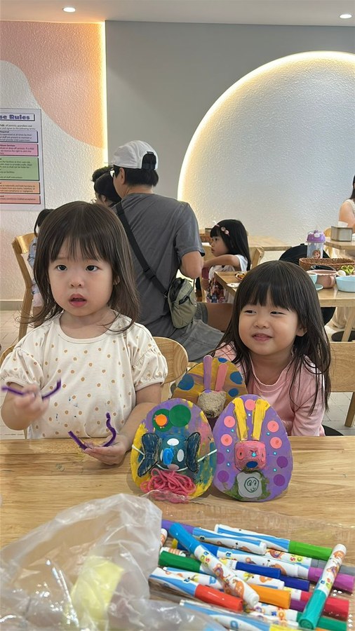 Children showing off their painted egg crafts