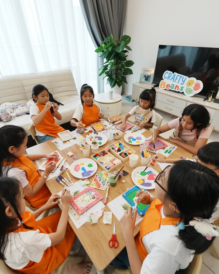 Children crafting picture frames together at a table