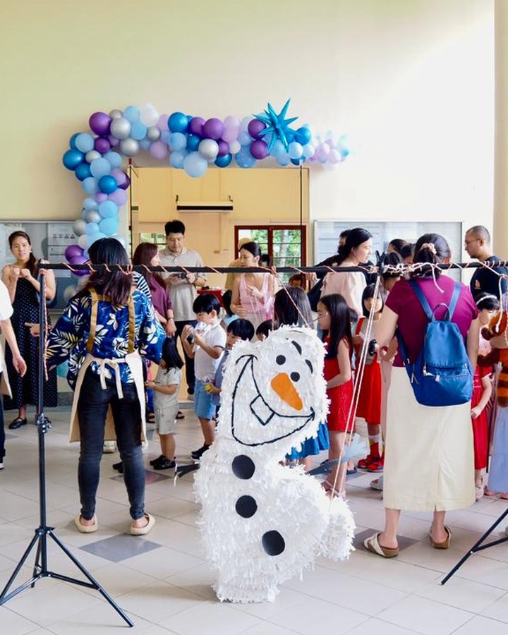 Families gathered around an Olaf pinata at a party