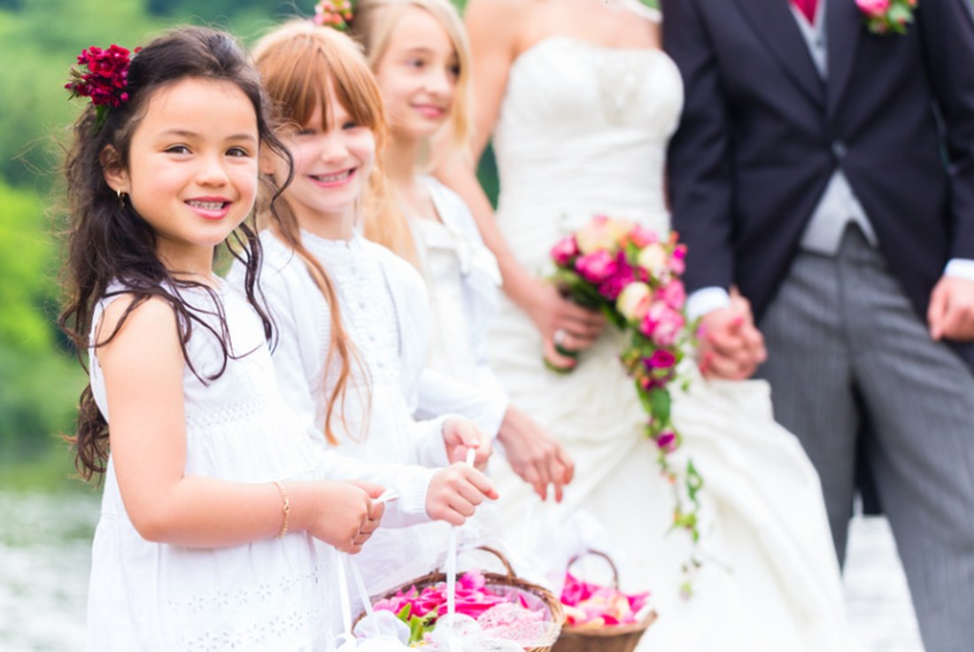 Flower girls walking with the bride and groom at a wedding
